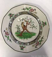 Full view of vintage Royal Doulton Pekin plate showing octagonal shape, bird perched on tree, floral border and gold trim.