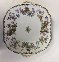 Top view of the square cake plate showing floral and pagoda pattern with gold trim and handles.