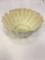 Top and side views of the small Beleek dish showing scalloped edge and ribbed sides in creamy off-white porcelain.