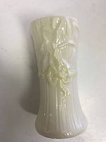 Small vintage Belleek porcelain vase showing embossed floral and bamboo design, glossy cream-white finish, 3.75 inches tall