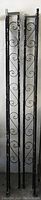 Full view of the two vintage black metal porch railings standing vertically.