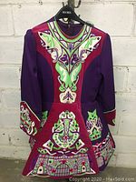 Full front view of vintage 1980s Irish dancing dress in purple and deep red with colorful embroidered Celtic designs.