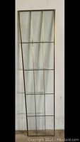 Full image of the large rectangular beveled glass panel with brass framing showing multiple vertical and horizontal divisions.