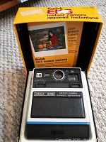Kodak EK6 instant camera with original packaging and instruction booklet showing box front graphics and product.