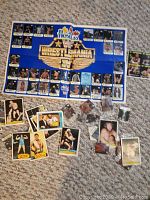 Wrestling stickers and trading cards displayed on carpet, includes a folded poster sheet and individual loose cards.