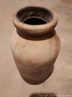 Beige ceramic vase with wide thick rim and cylindrical shape, showing surface wear and dirt from underwater recovery.