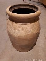 Photo of large antique pot or vase showing overall shape, wide mouth, and weathered surface.