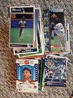 Top view of baseball cards showing various players including Moises Alou and Mitch Webster, arranged in stacks with visible card fronts.