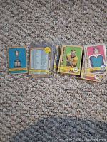 Photo of several 1972-73 OPC and Topps hockey cards laid out on a carpet, including a Stanley Cup trophy card, roster card, and player cards.