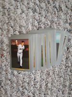 Stack of Topps baseball rookie cards from 2002 showing front of cards with players in various poses and team uniforms on beige carpet background.