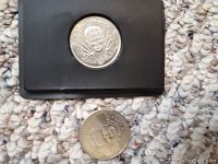 Photo shows two commemorative hockey coins featuring Mike Osgood and Marc-Andre Fleury, one displayed on a black stand and the other lying flat.