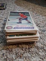 Stack of hockey cards featuring Yvan Cournoyer in Montreal Canadiens red uniform skating with hockey stick.