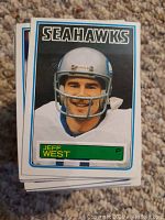 Front image of Topps football card showing Jeff West in Seahawks helmet and uniform with vintage 1983 design