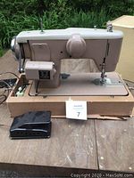Front and side view of the beige Riccar vintage sewing machine on cardboard base, including detached black foot pedal.