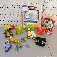 Overall lot showing vintage Fisher Price musical toys, dinosaur figurines, Barney toy, View-Master, and the boxed Teddy Ruxpin outfit