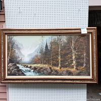 Full view of the large framed oil painting showing mountain landscape with stream and birch trees, wood frame with ornate detailing