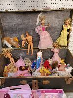 Open steamer trunk with vintage Barbie dolls, Kiel dolls, and Barbie dog with various clothes and some damage.