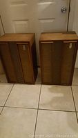 Pair of wooden cabinet speakers front view on tiled floor