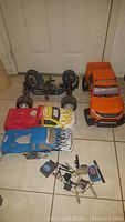 Lot photo showing two RC cars and various extra parts on floor.
