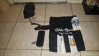 Full view of ankle foot orthoses with padded straps and Otto Bock branded mesh bag on tile floor.