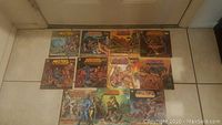 Eleven Masters of the Universe Golden Books laid out on the floor showing various illustrated covers.