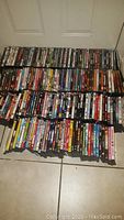 Full view of a large collection of DVD cases organized on the floor showing a variety of titles and genres.