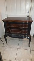 Full view of the Hooker Furniture 2 drawer bachelor chest in dark wood with curved front and cabriole legs.