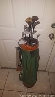Full set of golf clubs in green Palmer bag showing multiple clubs with visible wear.