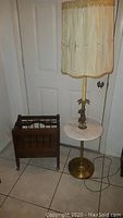 Full view of magazine rack and floor lamp showing their overall condition and placement.