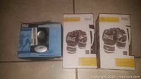 Two new Everlast MMA grappling gloves in original packaging alongside Pyle Sports heart rate watch in box.