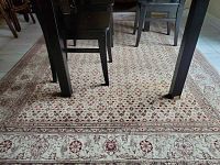 Carpet under dining table showing detailed low weave floral pattern and overall condition.
