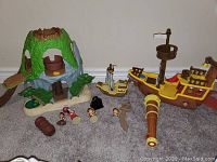 Photo showing the Tiki Island playset, large and medium pirate ships, five character figurines, and pirate-themed accessories.