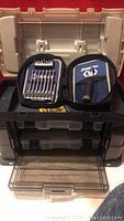 Large Plano tool box partially open showing internal compartments and some tools.