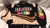 Front-upper portion of the M&M's NASCAR jacket showing colorful M&M's logos and part of sleeve design.