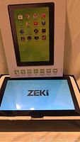 Tablet powered on showing ZEKI boot screen with box showing image of tablet and icons of apps.
