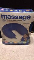 Front of box shows the product name, blue U-shaped neck cushion, and an image of a person using it on their neck.