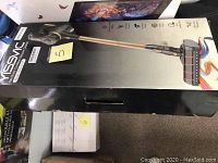 Box showing Yissvic handheld vacuum cleaner with gold handle and nozzle head with multi-colored design.