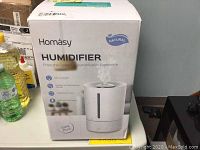 Box front and product image showing Homsay humidifier with branding and main features.