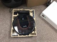 Robot vacuum and accessories seated in molded pulp tray