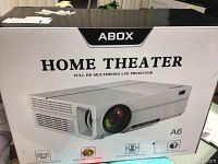 Front of ABOX Home Theater A6 projector box showing branding and product image.