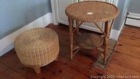 Wicker ottoman and wicker side table near walls on wooden floor with worn spots