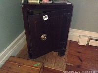 Front view of wood-cased safe with door ajar showing exterior design