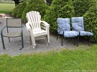 Set of 6 patio chairs arranged on gravel with lawn and shrubbery background. Shows all chair types including stacked Adirondack chairs and metal framed chairs with and without cushions.
