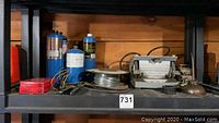 Shelves with propane tanks, welding wire, various small parts and tools.