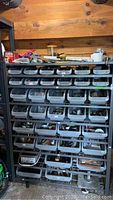 Full view of the shelving unit with multiple bins containing various hardware and parts