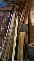 Pile of assorted wood boards leaning against wall including some tongue and groove