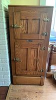 Front exterior view of oak icebox showing two doors and brass hardware