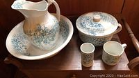 Image showing entire set including pitcher, washbowl, cups, and commode with lid on wooden surface.