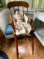 Child's antique high chair with spindle back and wooden legs, showing overall condition.