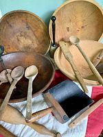 Three wooden bowls, spoons, pestles, flour scoop displayed together